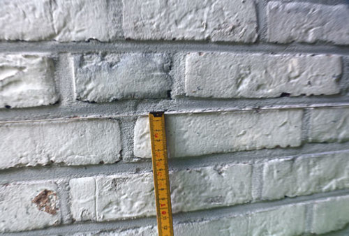 La rectitude des joints verticaux d’une maçonnerie de briques se mesure au moyen d’une corde tendue et d’un mètre pliant.